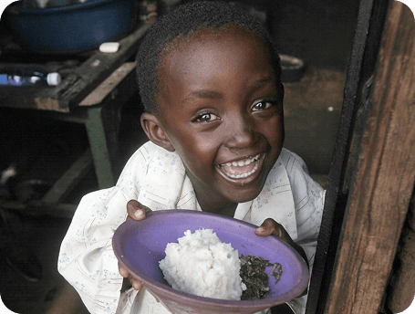 Crianca sorrindo com prato de comida